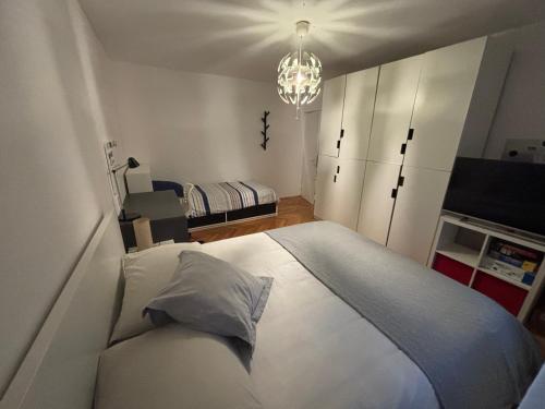 a bedroom with a white bed and a chandelier at Apartman Maja in Vodice