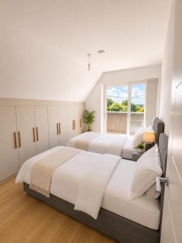 a bedroom with two beds and a window at Barnet Luxe 2 Bedroom Penthouse in Barnet