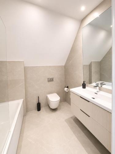 a bathroom with a sink and a toilet and a tub at Barnet Luxe 2 Bedroom Penthouse in Barnet