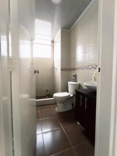 a bathroom with a toilet and a sink at APTO CENTRO DE MELGAR CON PISCINA EN CONJUNTo in Melgar