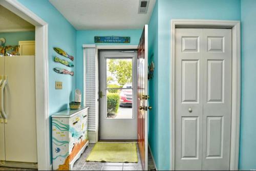 a hallway with blue walls and a white door at Nice N Myrtle beach house in Little River