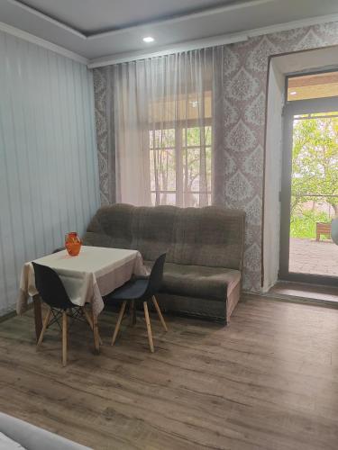 a living room with a couch and a table and chairs at STEPANAVAN guesthouse in Stepʼanavan