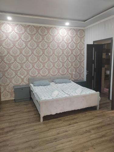 a bedroom with a bed and a wall at STEPANAVAN guesthouse in Stepʼanavan