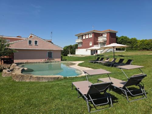 a pool with tables and chairs in a yard at Finca SOTOMAR-casa rural Simancas in Simancas