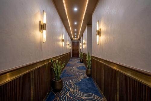 a hallway with potted plants in a building at Hotel Nexus Cyber Hub Near Rapid Metro & Ambience Mall in Gurgaon