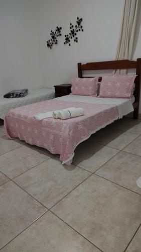 two beds in a room with pink sheets and pillows at Pousada dos Cuiabás in Tiradentes