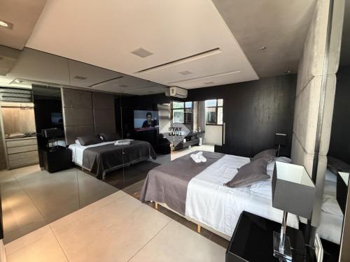a hotel room with two beds and a television at Ville Celestine Condo Hotel 704 in Belo Horizonte