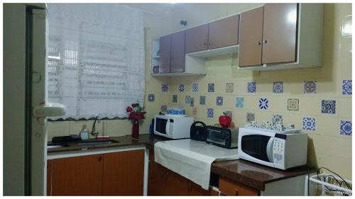 a kitchen with two microwaves and a microwave at Cacau Hostel in Goiânia