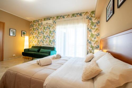 a large white bed in a room with a window at La Zagara Rooms - Porto di Milazzo in Milazzo