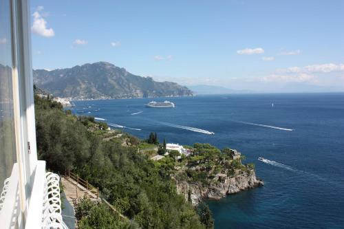 a view of the ocean with a cruise ship at Casa Reginella - Borgo Marinaro in Conca dei Marini