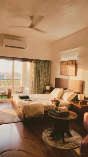 a bedroom with a large bed and a table at Bs BnB Luxury Studio Apartment in Dehradun