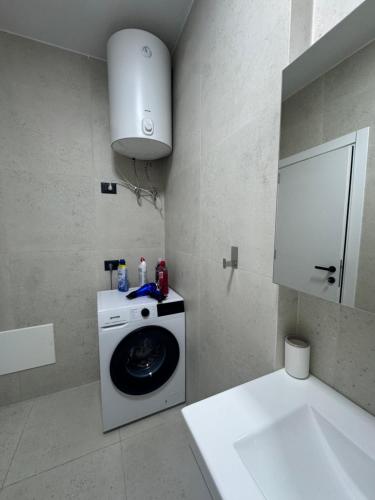 a bathroom with a washing machine and a sink at Dio East Apartments in Tirana