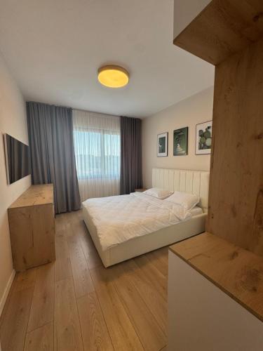 a bedroom with a white bed and a window at Dio East Apartments in Tirana