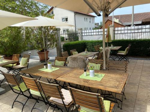 a wooden table with chairs and an umbrella on a patio at Alte Brauerei Mertingen in Mertingen