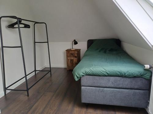 a room with a bed and a chair in a attic at Oevr652 in Earnewâld
