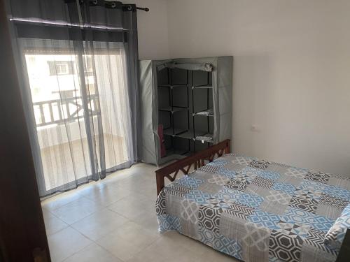 a bedroom with a bed and a large window at Chic apartment with secure pool in Oued Laou