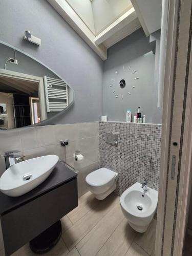 a bathroom with a sink and a toilet and a mirror at Attico Casa ReGa - private parking and bbq in Quartu Sant'Elena