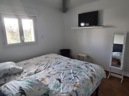 a bedroom with a bed and a flat screen tv at Comfortable apartment with mountain views in Ghisonaccia