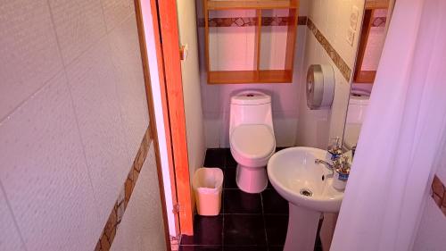 a small bathroom with a toilet and a sink at Hostal Open House in San Pedro de Atacama