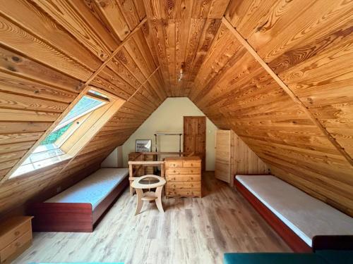 a room with a large wooden ceiling with a window at Gąsiorówka in Gryżyna