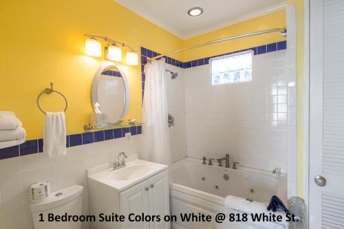 a bathroom with a white tub and a sink at Colors on White in Key West