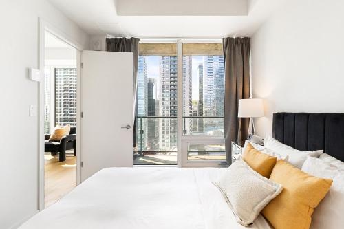 a bedroom with a white bed and a large window at Luxury Apartments with View & Indoor Heated Pool in Montreal