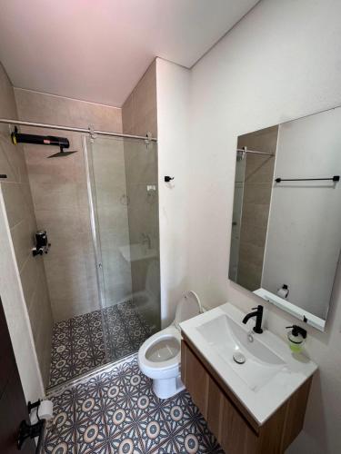 a bathroom with a shower and a sink and a toilet at VILLA DEL ROSARIO in Tena