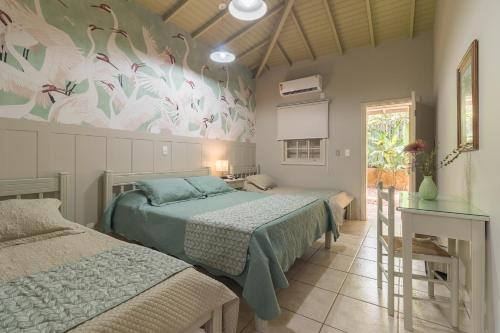 a bedroom with two beds and a mural of birds at Villa do Conde in Brotas