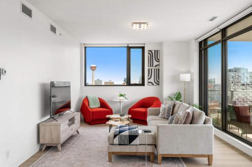 a living room with a couch and red chairs at Nuage 2 Bed 2 Bath 2 Balconies Parking in Calgary