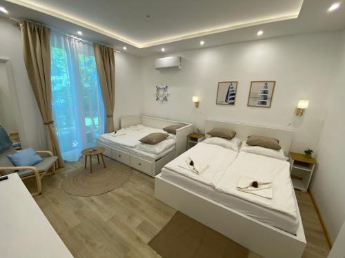 a bedroom with two beds and a living room at Arany Toboz Vendégház in Siófok