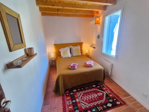 a bedroom with a bed and a window and a rug at Fajureya House in Vaumeilh