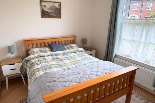 a bedroom with a wooden bed and a window at Charming Lisburn Flat with private parking in Lisburn