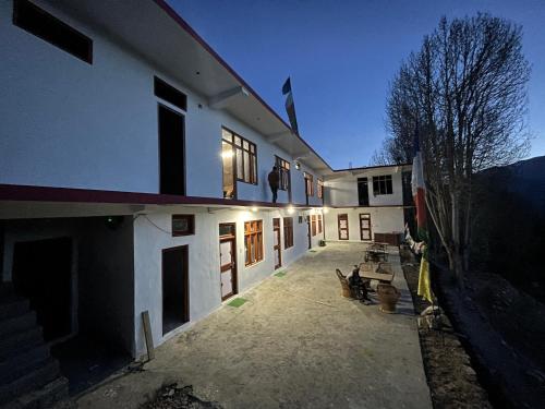 a building with a group of people sitting outside of it at Moon Lake Hotel, Nako in Nako