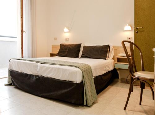a large bed in a room with a table and chairs at Hotel Ristorante Selene in Alba Adriatica