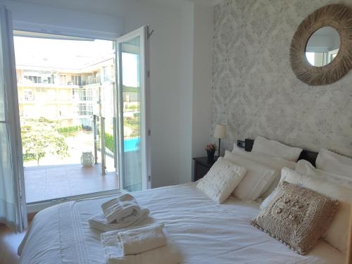 a bedroom with a white bed with towels on it at Marzan Playa in Foz