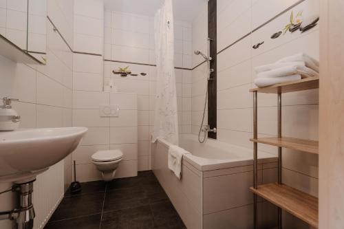 a bathroom with a sink and a tub and a toilet at Zimmer Zur Säge in Kötschach