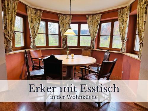 a dining room with a table and chairs and windows at VILLA SEEBERG - by "Schloss Gessenberg" luxurious vacation home with lake and mountain views, suitable for families and friends in Petting