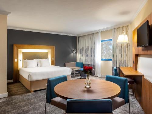 a hotel room with a bed and a table at Novotel Port Harcourt in Port Harcourt
