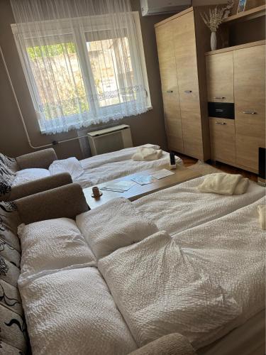 a large white bed in a bedroom with a window at Welcome Ma-Ko in Makó