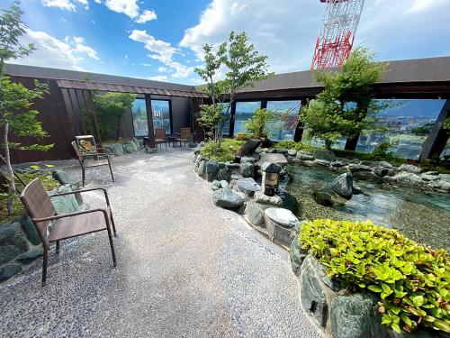 a house with a pond in front of a building at Dormy Inn Hirosaki in Hirosaki