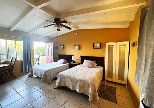 a bedroom with two beds and a table and a window at Harmony Motel in Twentynine Palms