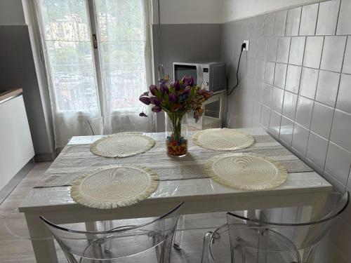 a table with three plates and a vase of flowers on it at I Tulipani in Genoa