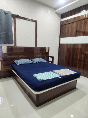 a bedroom with a bed with a wooden head board at Holiday Home Madurai - Duplex Villa Umachikulam in Madurai