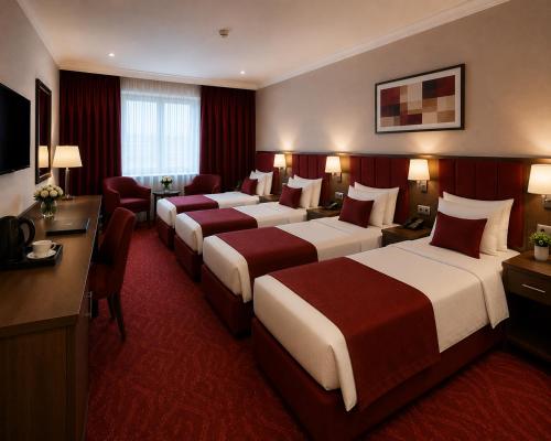 a hotel room with four beds and a desk at Khatai Center Hotel in Baku
