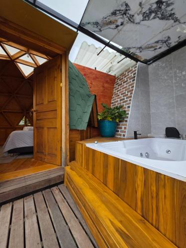 a large bathroom with a tub and a bedroom at Benigno Mirador in Guatavita