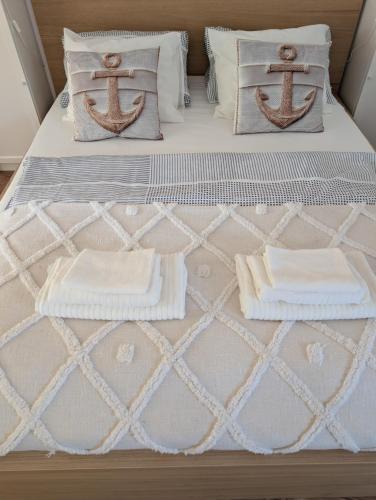 a bed with two pillows and towels on it at Balatonfenyvesparti kisház in Balatonfenyves