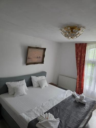 a bedroom with a bed and a chandelier at Happy Family in Suceviţa