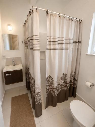a bathroom with a shower curtain and a sink at Pousada Mais Cacau in Itu