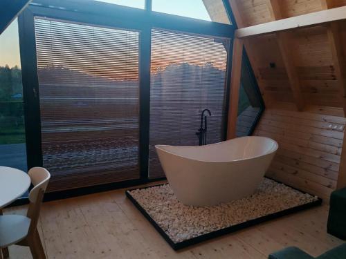 a large bathroom with a tub and a large window at Shemoqmedi Chalet in Zemo Makvanetʼi