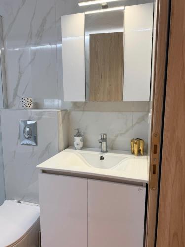 a white bathroom with a sink and a mirror at G&D guest house in Ancient Epidauros